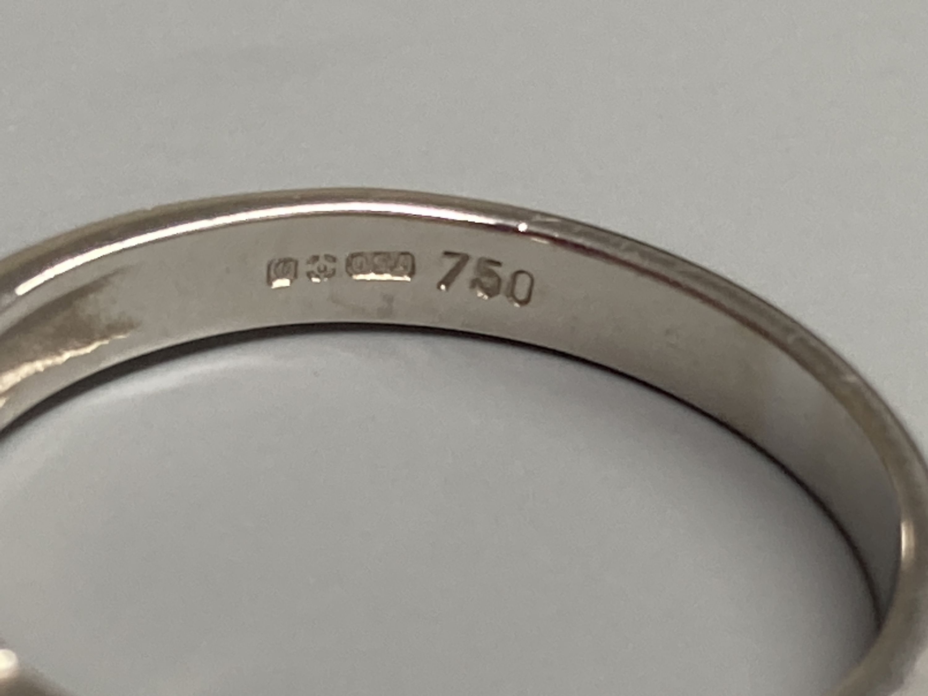 A modern 18ct white gold, sapphire and diamond set three stone ring, size N/O, gross 3.2 grams.